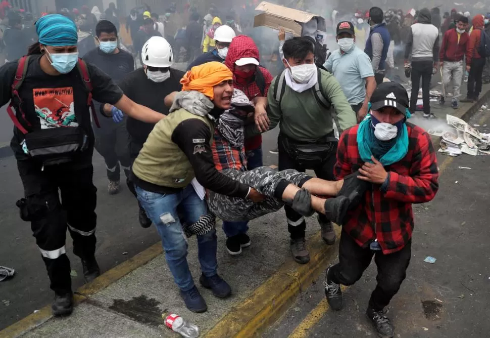 CHOQUES. Un manifestante herido es apartado del centro del enfrentamiento con las fuerzas de seguridad.  