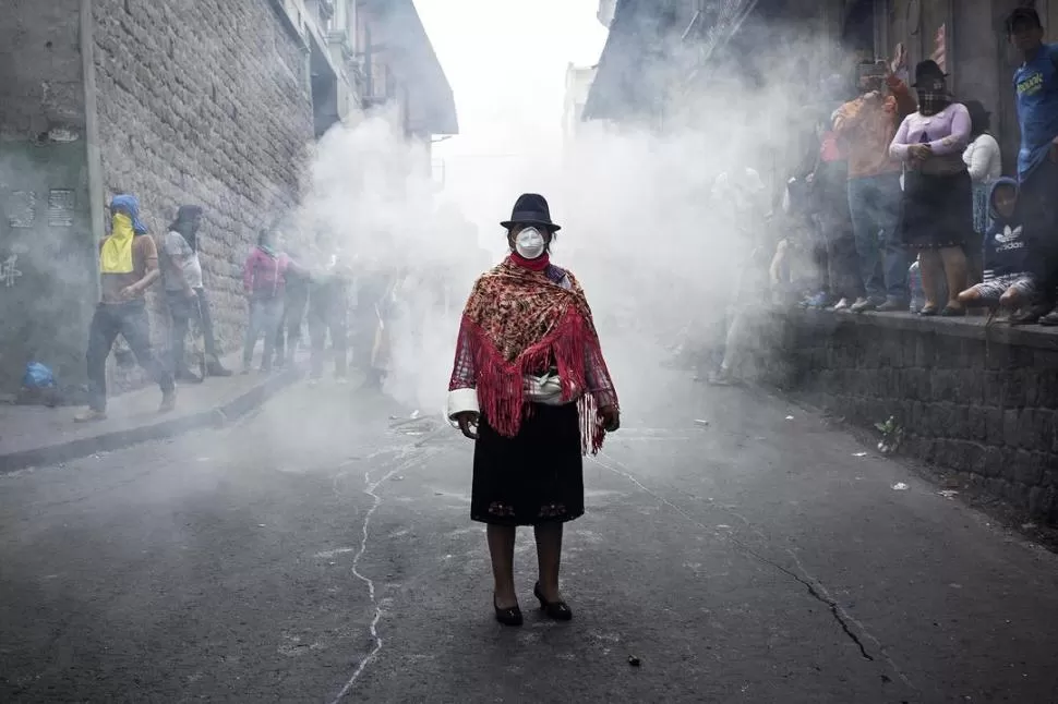 VIRAL. La foto de una mujer de Cotopaxi, con ropa de gala y barbijo para los gases, se convirtió en un símbolo de la protesta. AGENCIA BLOOMBERG / foto de DAVID DÍAZ ARCOS