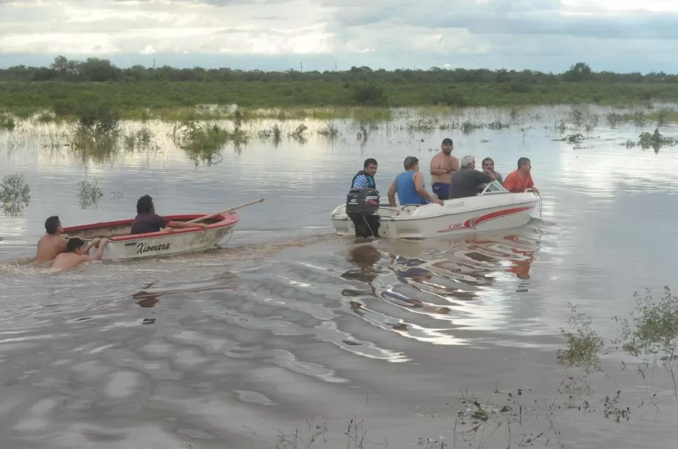 DESAMPARADOS. Un grupo de vecinos de La Madrid circula en bote por la zona inundada durante la catástrofe de abril de 2017.