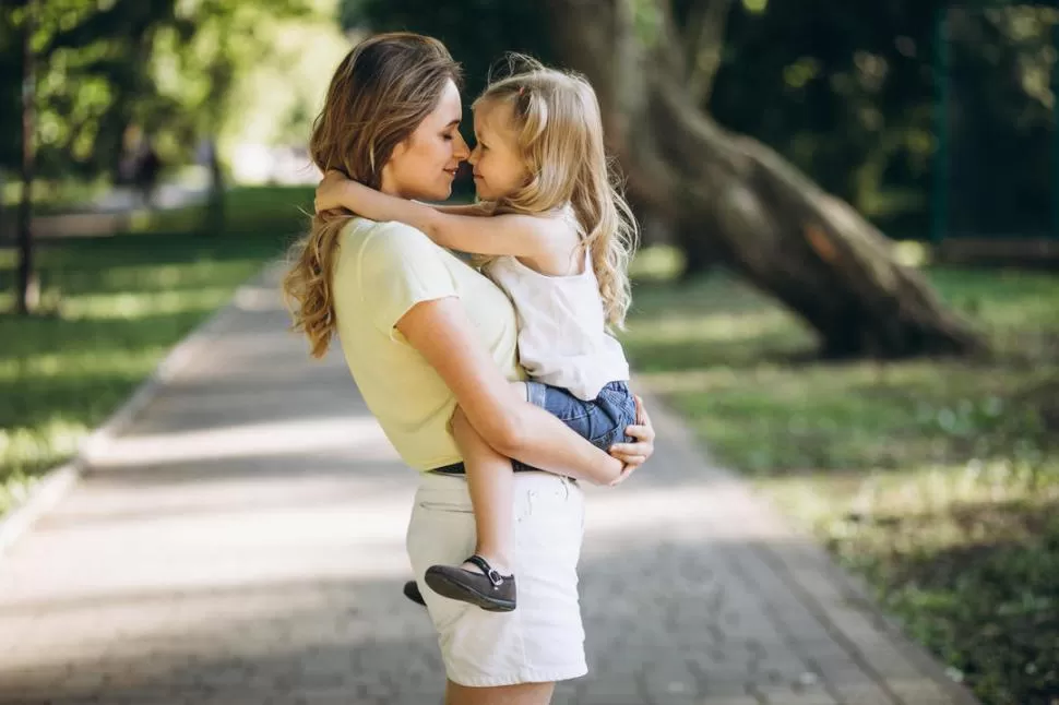 DÍA DE LA MADRE. Una mamá y su hijita se abrazan al aire libre. Este día es una de las festividades más lindas del año y hay que celebrarla. 