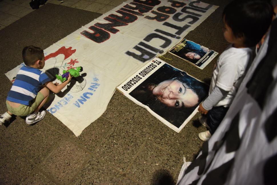 “JUSTICIA POR MARIANA”. Un pequeño hace sombra con su juguete sobre una bandera de reclamo, ubicada en el piso de la plaza Independencia. 