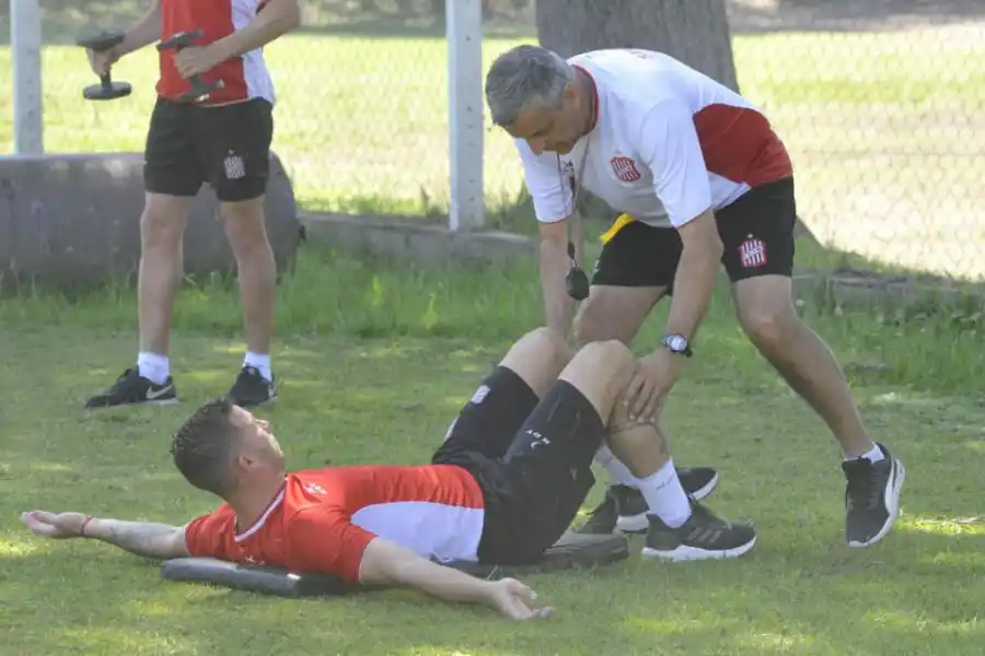 CUIDAN AL GOLEADOR. El “profe” Ricardo Somma ayuda en la elongación a Luciano Pons, la carta de triunfo “santa”.   