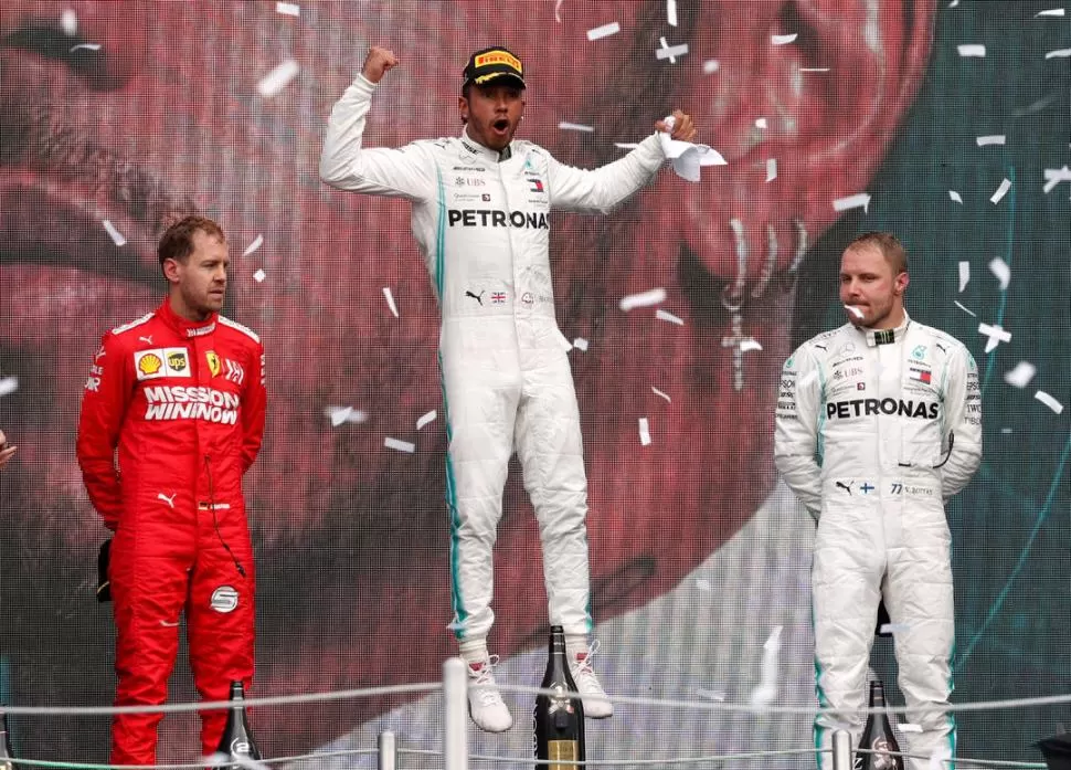 ROSTROS Y CONTRASTES. Mientras Sebastian Vettel y Valteri Bottas se muestran en el podio sin emociones, Lewis Hamilton aparece exultante, luego de ganar de manera inesperada el gran premio mexicano. reuters 