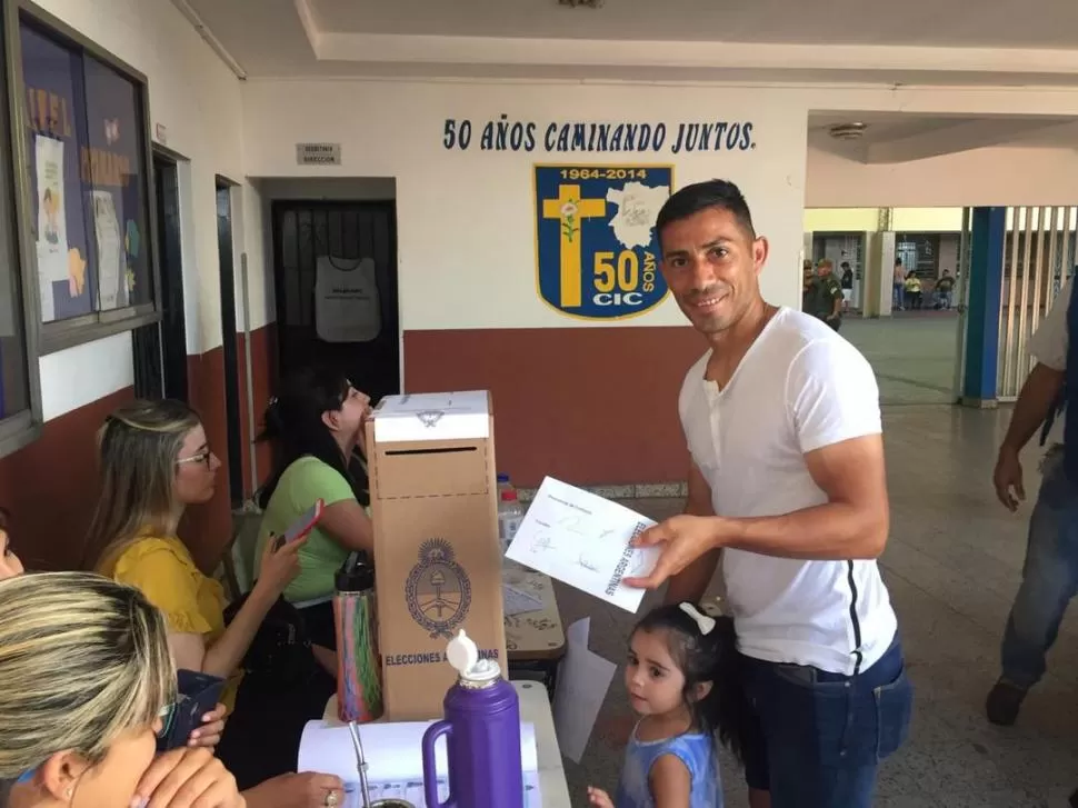 FRENTE A LA URNA. Guillermo “Bebé” Acosta a punto de emitir el voto, con la pequeña Oliva a su lado.  
