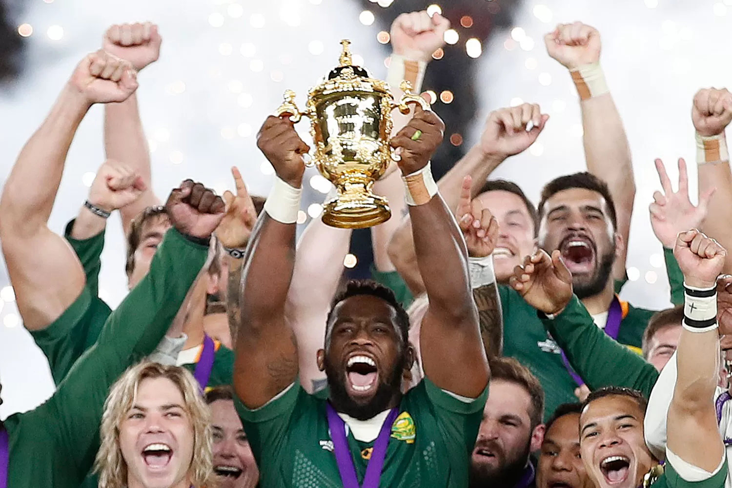 LOCURA VERDE. El capitán sudafricano, Siya Kolisi, levanta el trofeo, acompañado por sus alborozados compañeros. 