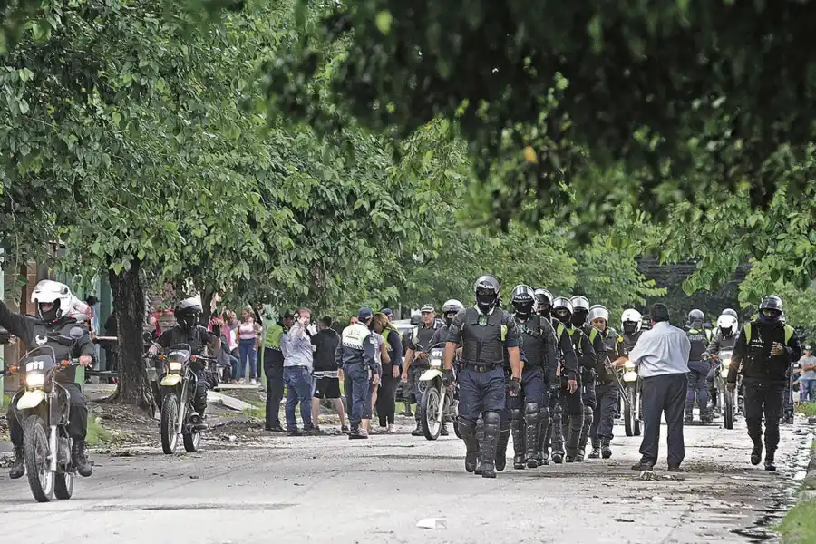 ESCENARIO. Los uniformados se desplazan en la zona del conflicto. Atrás, parientes y vecinos del joven asesinado. 