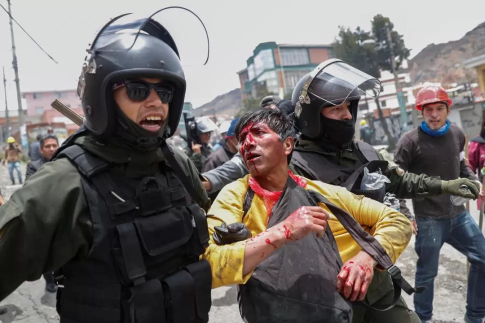 VÍCTIMA. En La Paz, un manifestante es asistido después del enfrentamiento entre partidarios de Evo y opositores.  
