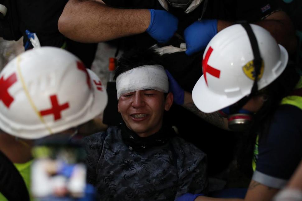 ASISTENCIA. Personal médico atiende a un chileno herido en la cabeza.