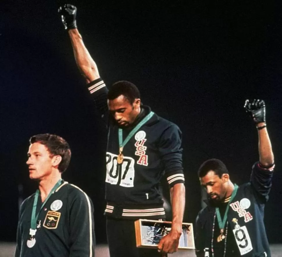 IMAGEN PODEROSA. Atletas estadounidenses en la célebre señal de protesta de los derechos civiles negros en su país. 