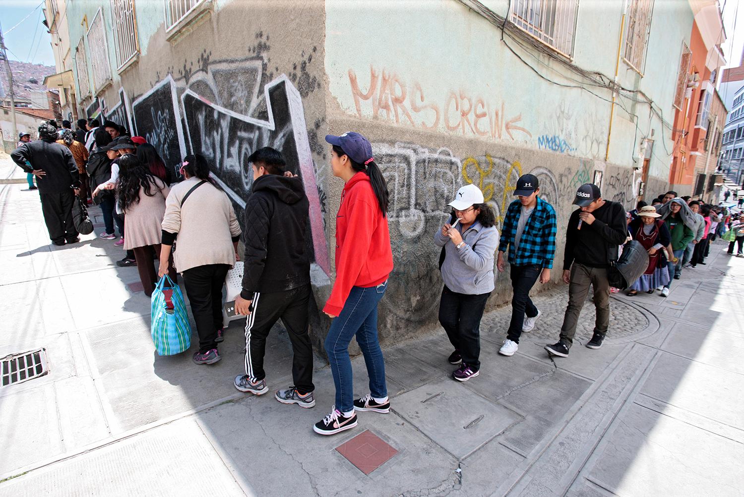Pobladores en La Paz hacen fila para recibir alimentos, por el desabastecimiento.