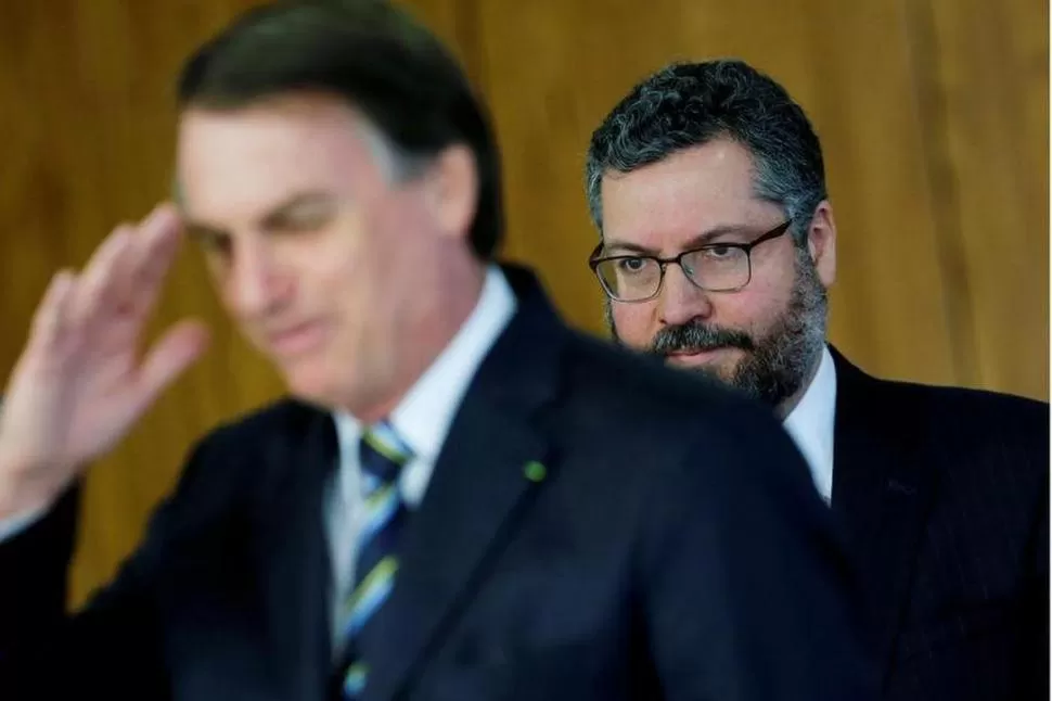 PORTAVOZ. Araújo, quien camina detrás de Jair Bolsonaro, expresó su incertidumbre ante la posible ruptura. reuters