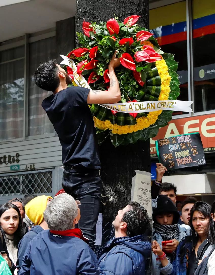 HOMENAJE. El lugar donde cayó Dilan Cruz se llenó de carteles y coronas con flores para recordar al joven.  Reuters