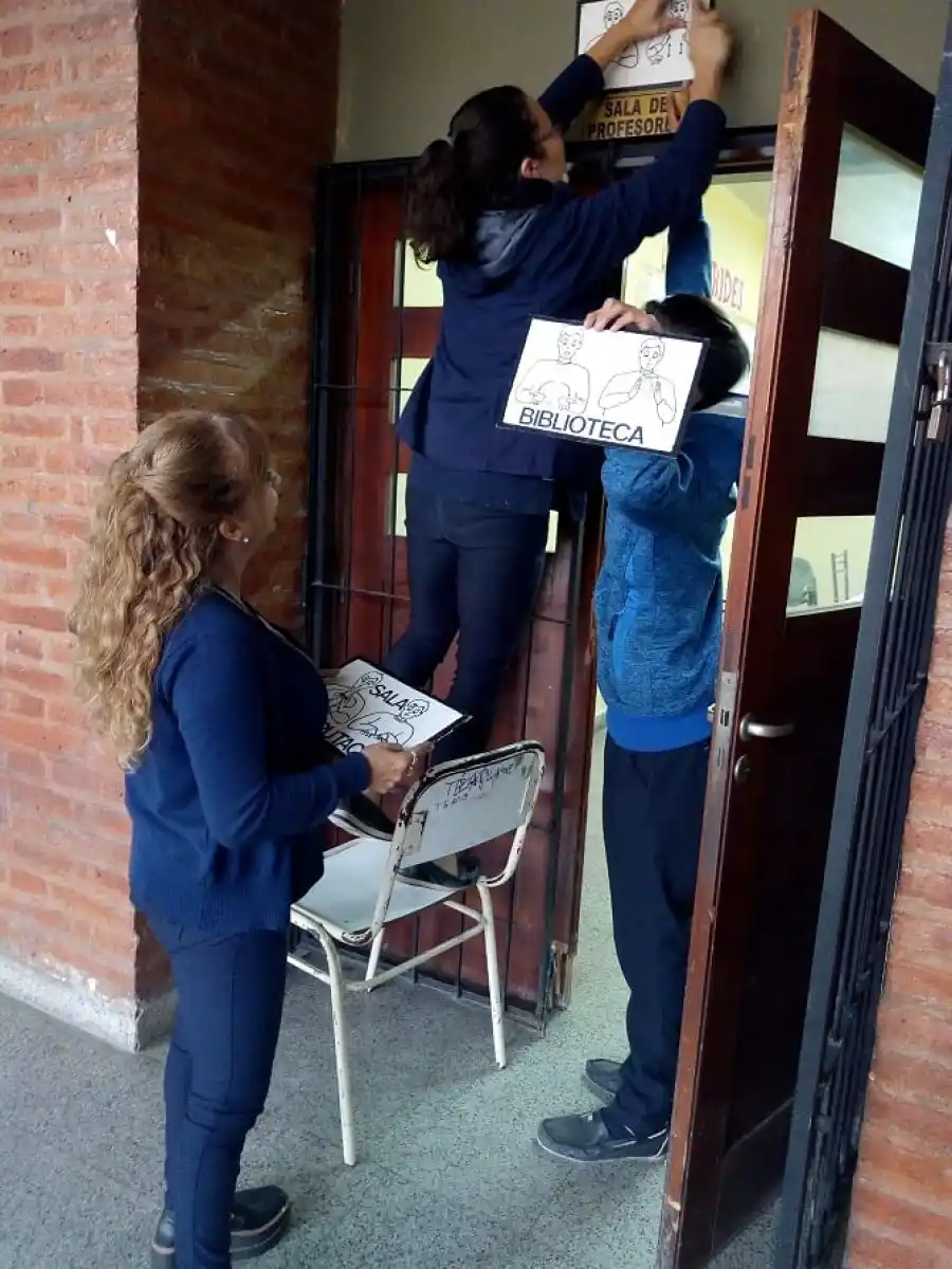 EN PRÁCTICA. Los docentes colocan uno de los carteles identificatorios.