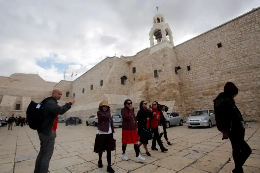  DE PASEO. Un grupo de turistas pasea por la Plaza del Pesebre, frente a la basílica de la Natividad.