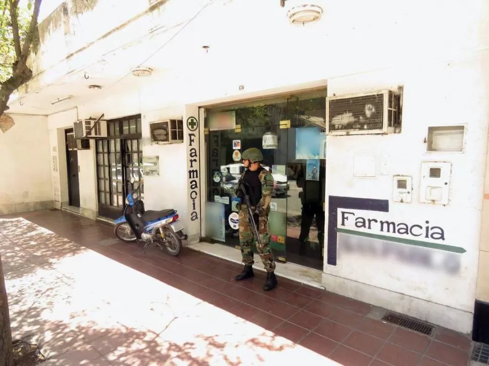 OPERATIVO. Un gendarme custodia el acceso a una farmacia de la capital. prensa gendarmería