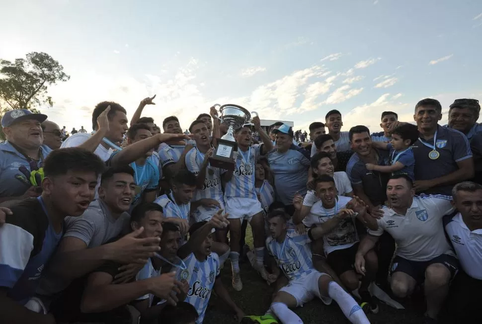 MOMENTO SUBLIME. El plantel de los “Decanos” exhibe orgulloso la copa que se adjudicó al ganar el Anual de Primera A de la Liga Tucumana de Fútbol. El equipo acertó en los penales y terminó festejando.  