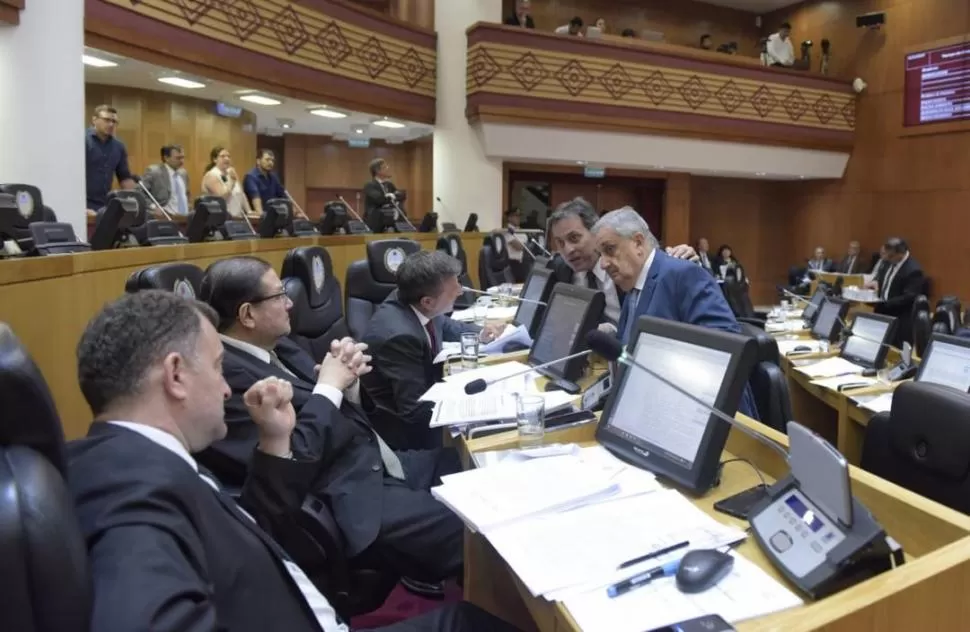 INTERCAMBIO. El experimentado legislador Ruiz Olivares (de pie) conversa con legisladores de la oposición, en busca de consensos durante la sesión de ayer. prensa legislatura