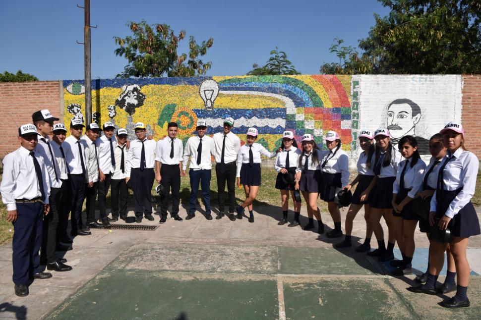LOS AUTORES. Delante del mural completo, los estudiantes de 6° año que pasaron meses juntando y pegando tapitas para dejar su mensaje. 