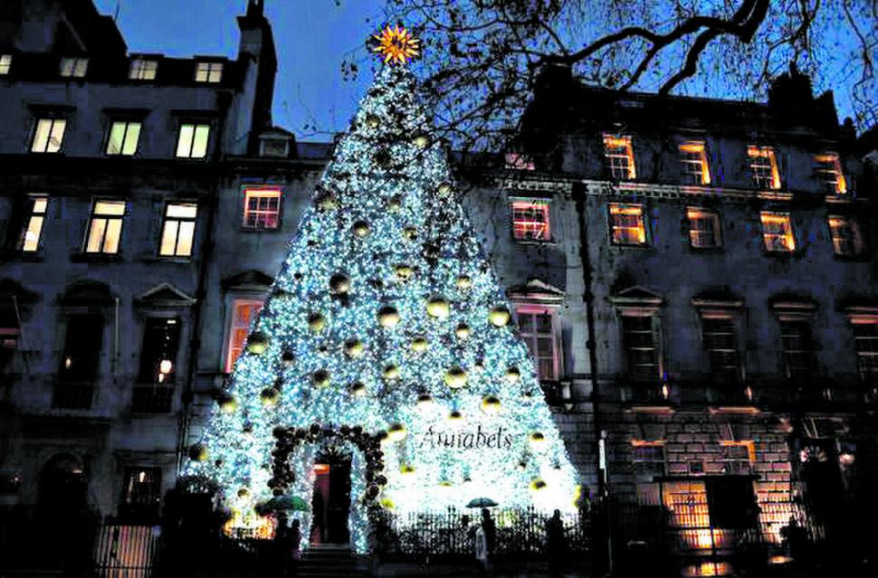 INGLATERRA. Entrada a todo lujo. Un árbol de Navidad cubre el frente de un club del barrio londinense de Mayfair.
