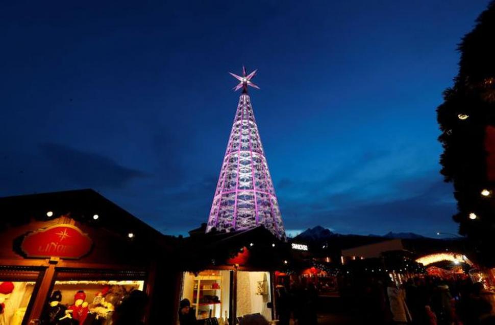 AUSTRIA. Un árbol, en el centro del paseo. La gente visita un colorido mercado navideño en Innsbruck.