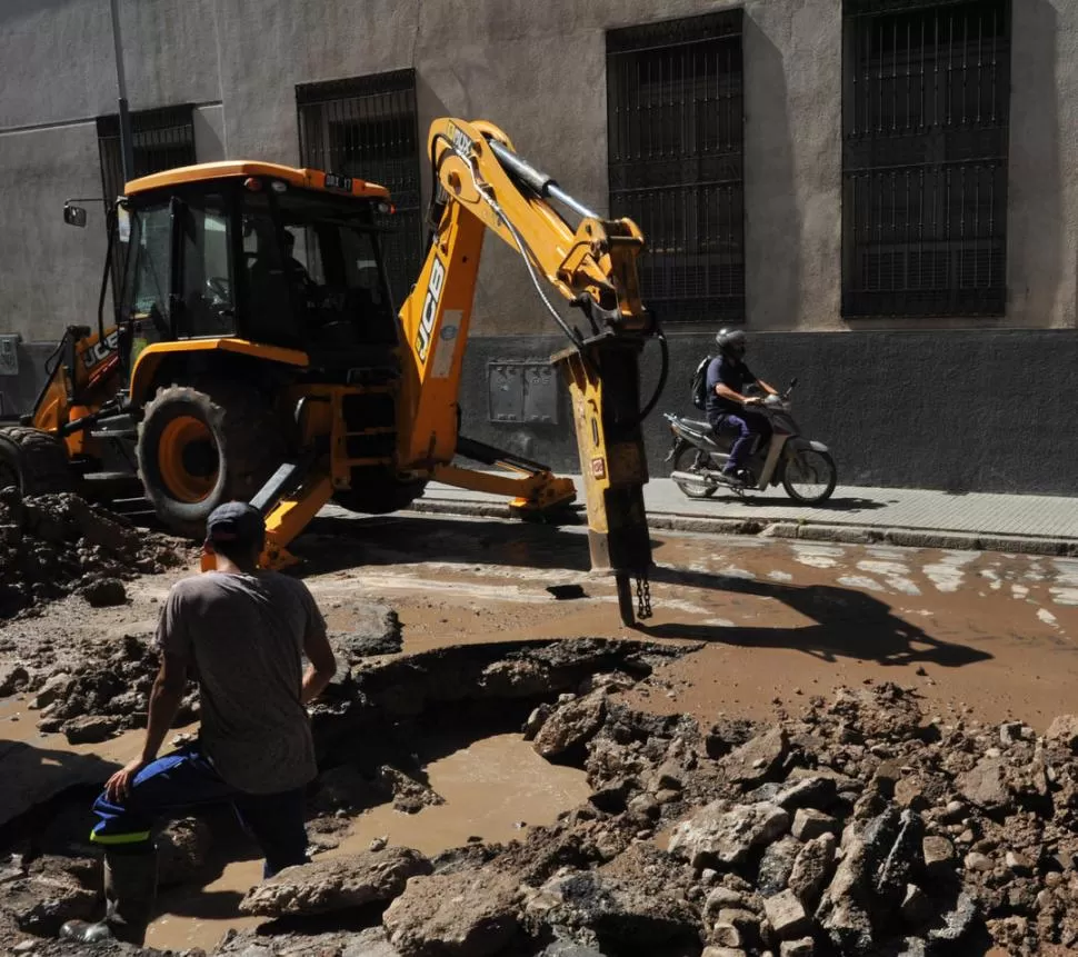 PARCHE. Obreros de la SAT trabajaban ayer en la Córdoba al 357. El asfalto cedió por filtración de agua. 