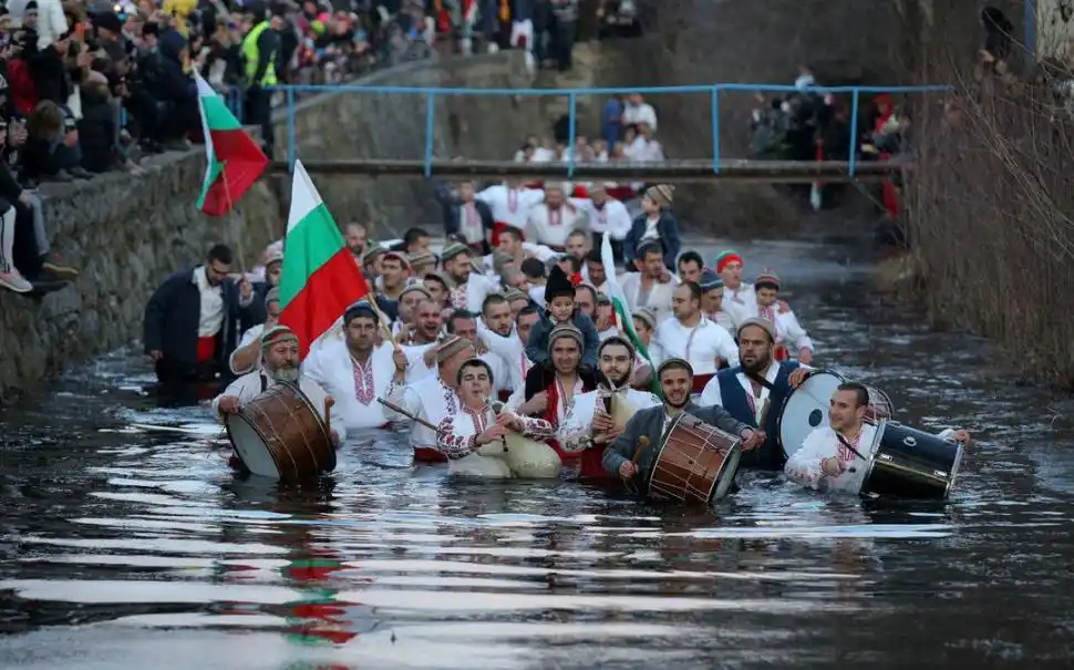 BULGARIA. Al ritmo de sus tambores y de sus gaitas, un grupo de hombres del pueblo de Kalofer, se adentran en las heladas aguas del río Tundzha, donde bailan una insólita danza festiva, tradicional de este país.