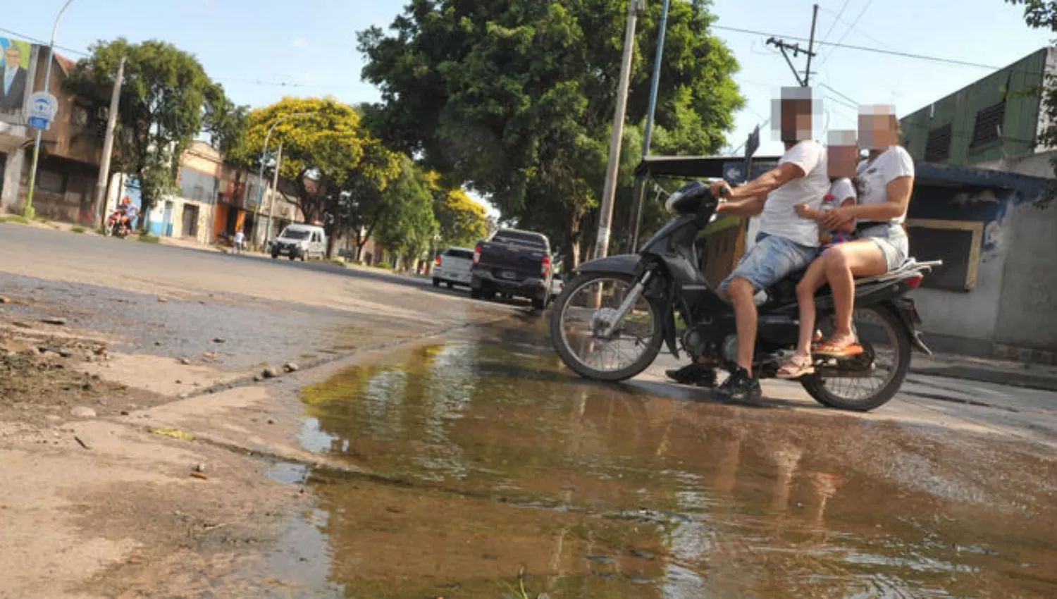 JUAN B. JUSTO Y VENEZUELA. Una pareja (con un niño pequeño sobre la moto) cruza la laguna que se formó en la esquina. la gaceta / fotos de ANTONIO FERRONI
