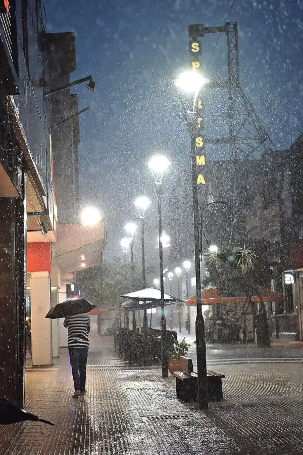 COMO UNA COPIOSA CORTINA. El volumen de la precipitación se advierte a la luz de las farolas de la desolada peatonal Muñecas. 