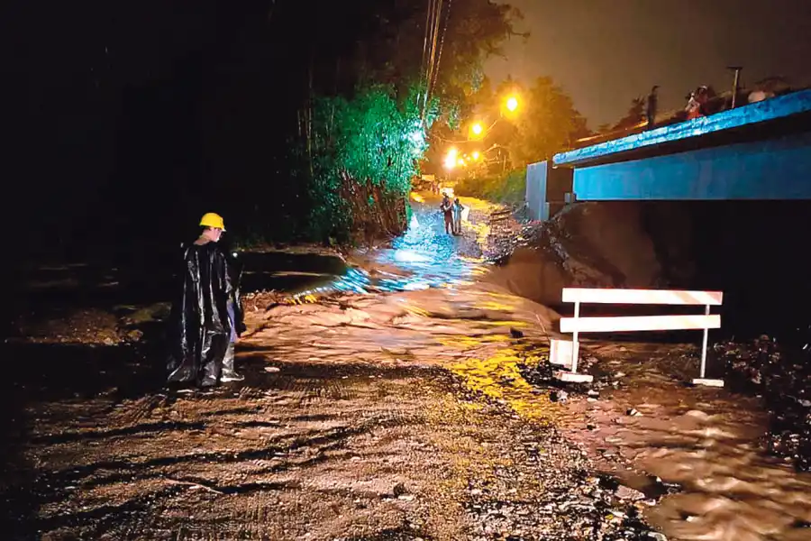 “NAVEGANDO” EN DOS RUEDAS. Un hombre habla por teléfono arriba de una moto. El nivel del agua es tal que no se distingue entre veredas y calles.