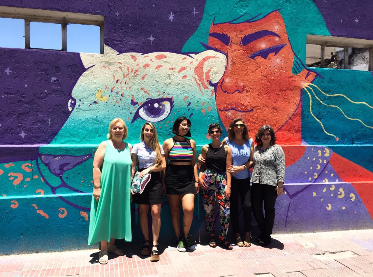 Artistas y vecinos tomándose una foto en un mural de Ayacucho al 200