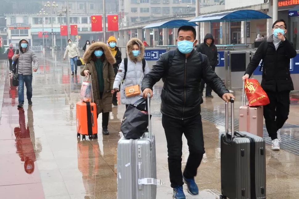 TODOS CON BARBIJOS. Un grupo de pasajeros llega a la estación de tren de Changsha, en China. reuters 