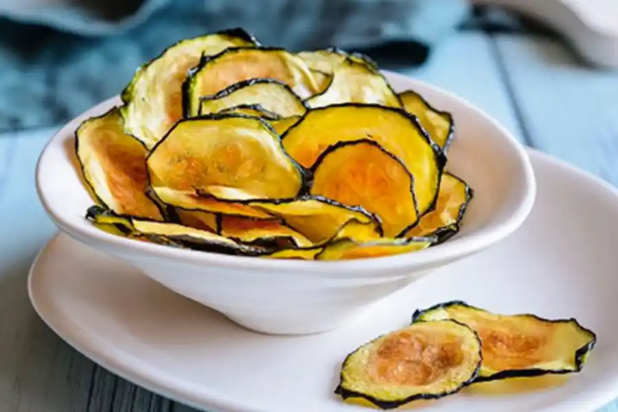 ZUCCHINIS. Chips diferentes. Colocar las rodajas cortadas con mandolina en una placa con papel manteca, bien separadas. Barnizar con pincel con la mezcla de las especias elegidas (sal, pimienta, ajo en polvo, pimentón, curry, ralladura de limón y/o cayena molida) y aceite de oliva. Hornear 15 minutos (foto de Matías Marchetti).