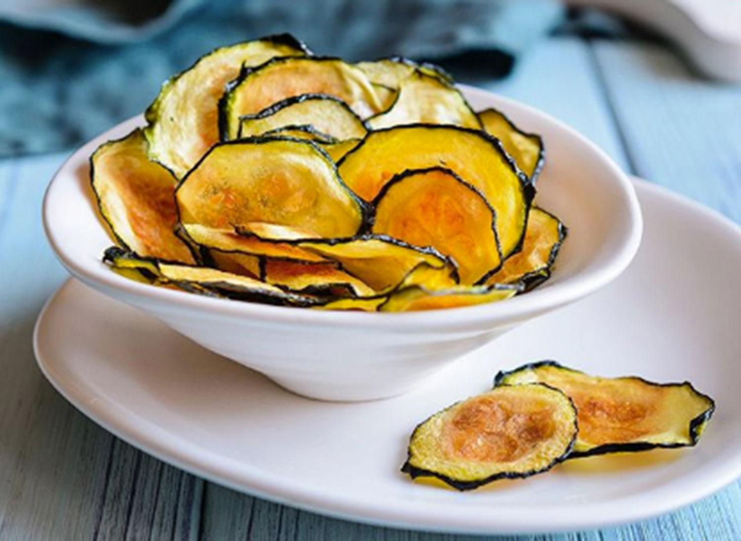 ZUCCHINIS. Chips diferentes. Colocar las rodajas cortadas con mandolina en una placa con papel manteca, bien separadas. Barnizar con pincel con la mezcla de las especias elegidas (sal, pimienta, ajo en polvo, pimentón, curry, ralladura de limón y/o cayena molida) y aceite de oliva. Hornear 15 minutos (foto de Matías Marchetti).