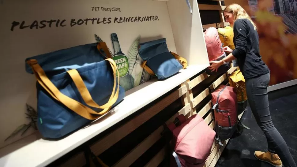 RECICLAJE. Una mujer observa bolsos fabricados con plástico de botellas. fotos reuters