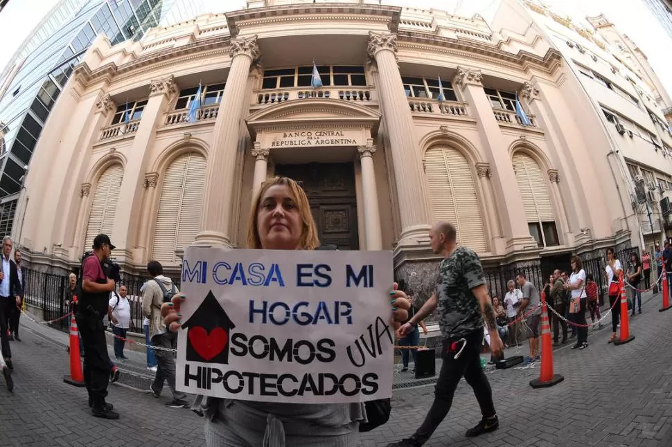 PROTESTA NACIONAL. Una mujer muestra un cartel con la consigna del día en la puerta del Banco Central. La manifestación recorrió todo el país. 