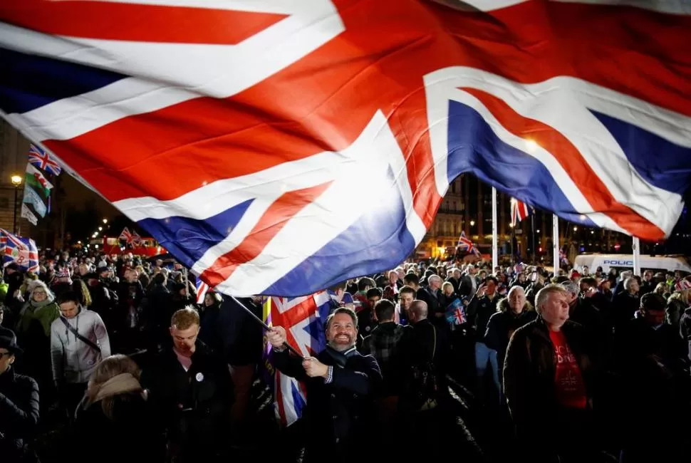 NOCHE HISTÓRICA. Un partidario del Brexit enarbola la “Union Jack” durante la previa de la oficialización de la salida. Reuters