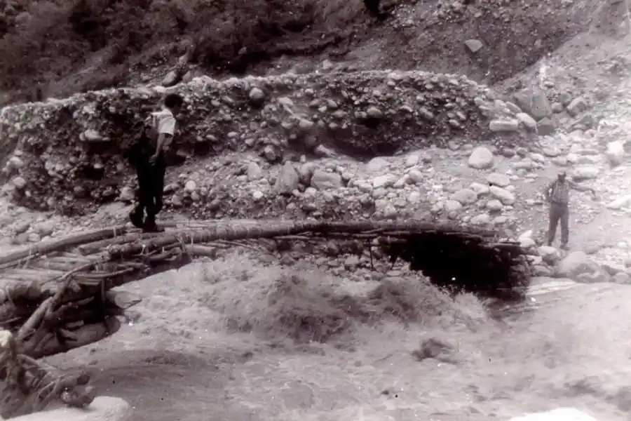 EN NEPAL. Un expedicionario cruza un precario puente sobre un río.