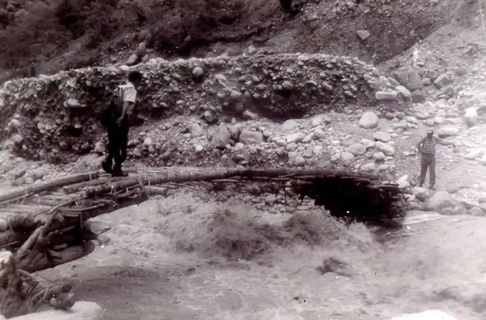EN NEPAL. Un expedicionario cruza un precario puente sobre un río.