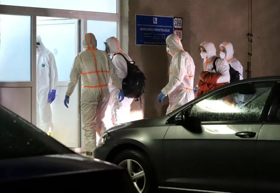 TAREAS PREVENTIVAS. Personal médico con traje de protección escolta a los dos ciudadanos eslovacos sospechosos de ser coronavirus después de ser evacuados de Wuhan, China. dpa