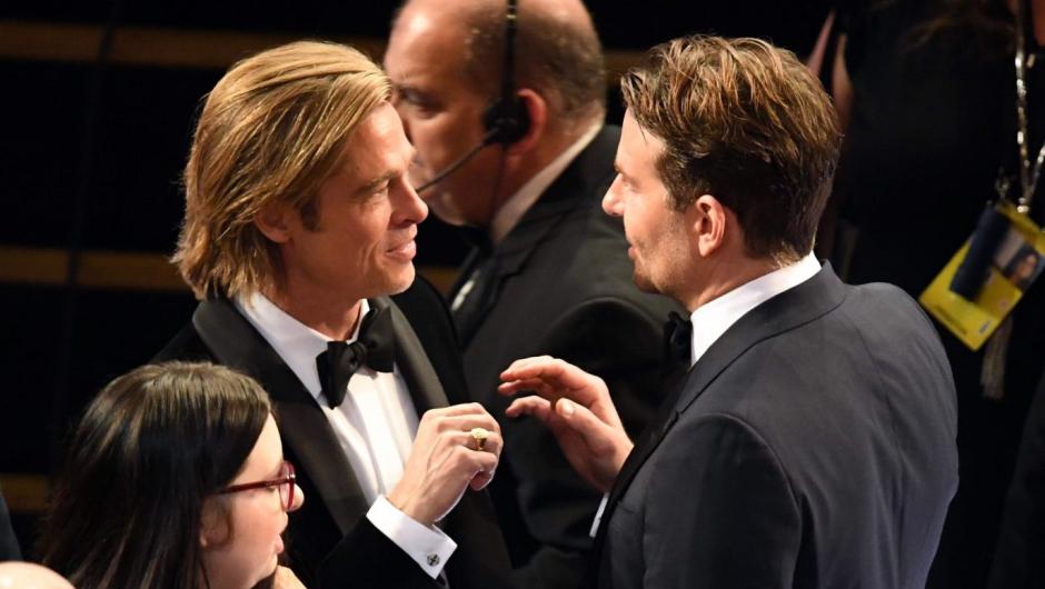 CHARLAS. Brad Pitt y Bradley Cooper, hablando en la pausa.