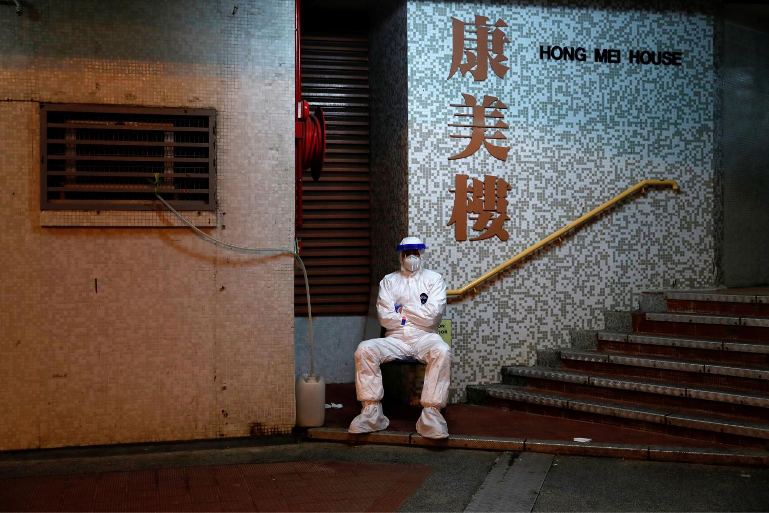 Un hombre en Hong Kong espera para evacuar a personas en un barrio.