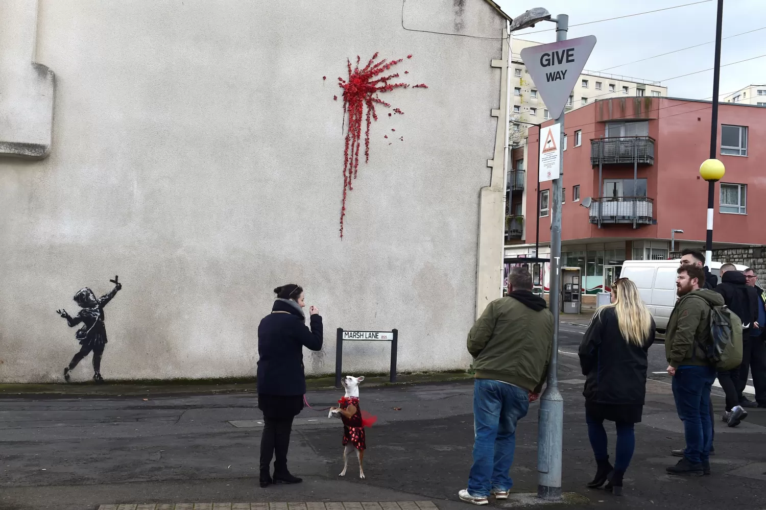 Los habitantes de Bristol se detienen a admirar la nueva obra del artista callejero.