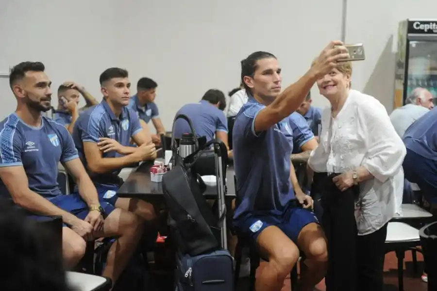 PARA EL RECUERDO. Dylan Gissi se toma una selfie con una señora, detrás, Camilo Albornoz y el “Oso” Sánchez observan la acción.  