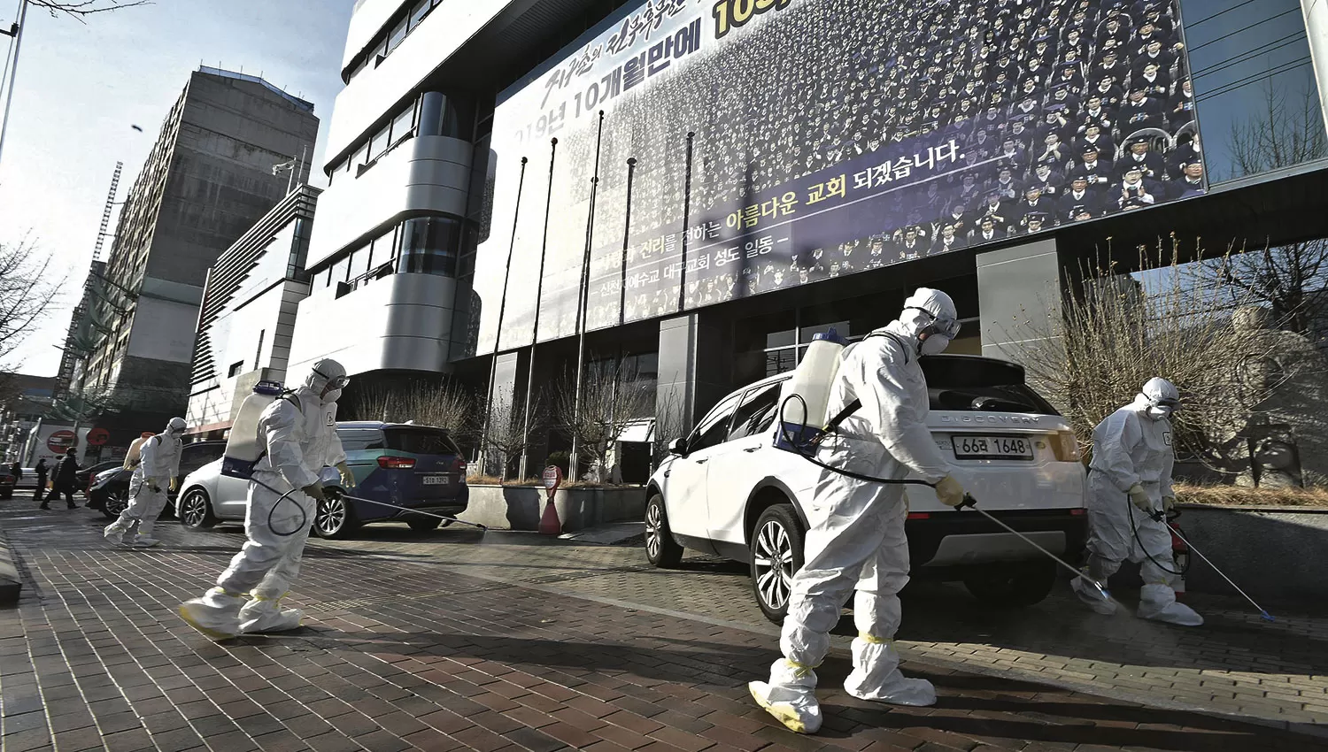 COREA DEL SUR. En Daegu, trabajadores  desinfectan una calle frente a la Iglesia Shincheonji de Jesús, donde la “Paciente 31” experimentó síntomas del virus.