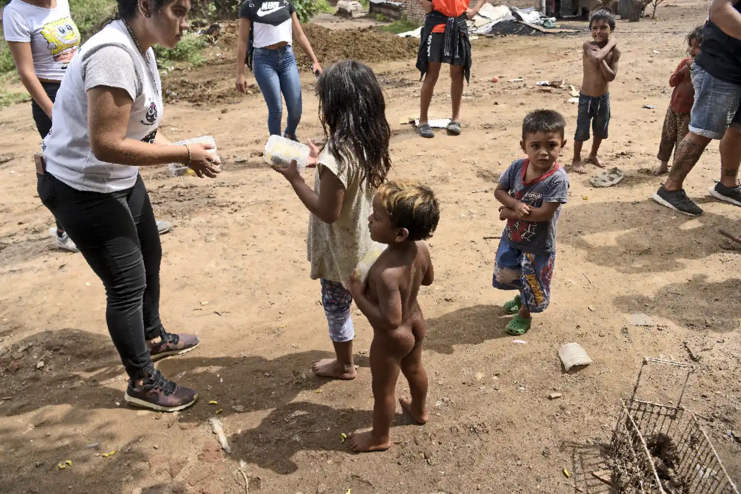LA INDIGENCIA. Una voluntaria se ocupa de que los chicos puedan comer.