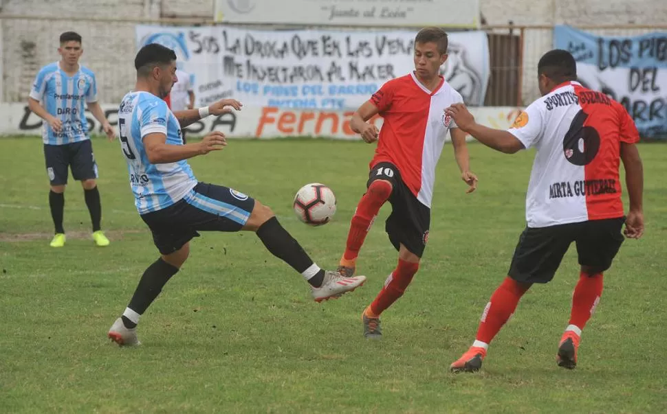 LUCHA EN LA ZONA MEDIA. Hasan Jadur, de Atlético Concepción, y Leonardo Rizo, de Sportivo Guzmán, disputan la pelota, ante la mirada de Mauricio Bustos.