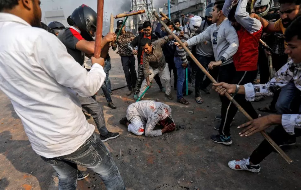 GOLPIZA. Una turba apalea a un musulmán, en una calle de Nueva Delhi.  reuters