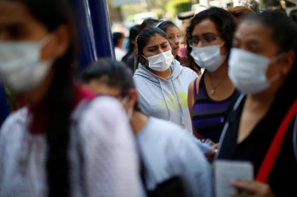 MÉXICO. Personas usando barbijos esperan afuera del Instituto Nacional de Enfermedades Respiratorias donde el paciente con coronavirus está siendo tratado. reuters 