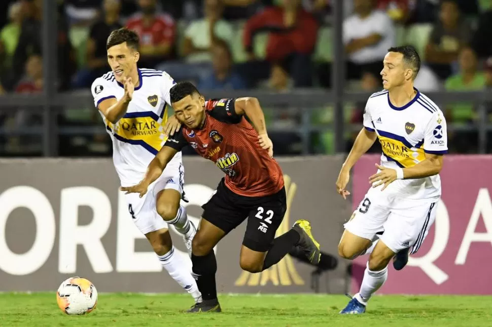 RODEADO. Echeverría intenta escaparse de las marcas de Capaldo y Jara. Boca se descuidó y dejó dos puntos importantes al empatar con Caracas FC, de visitante. cabj