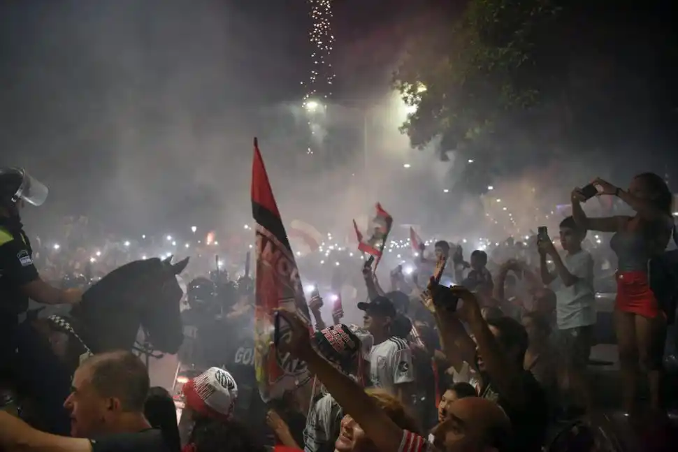 FIESTA MILLONARIA. No faltó nada en la llegada del plantel: bengalas, banderas y cánticos, recordando la final de la Copa Libertadores en Madrid. Los hinchas riverplatenses registraron todo en sus teléfonos.  